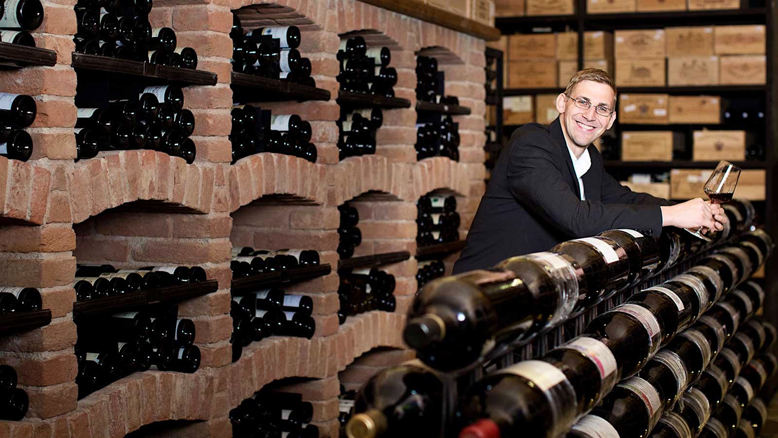 Wine director Wolfgang Kneidinger in the cellar of Palais Coburg, next to imperial bottles of wine